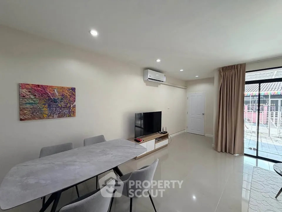 Modern living room with dining area and sliding glass doors to balcony