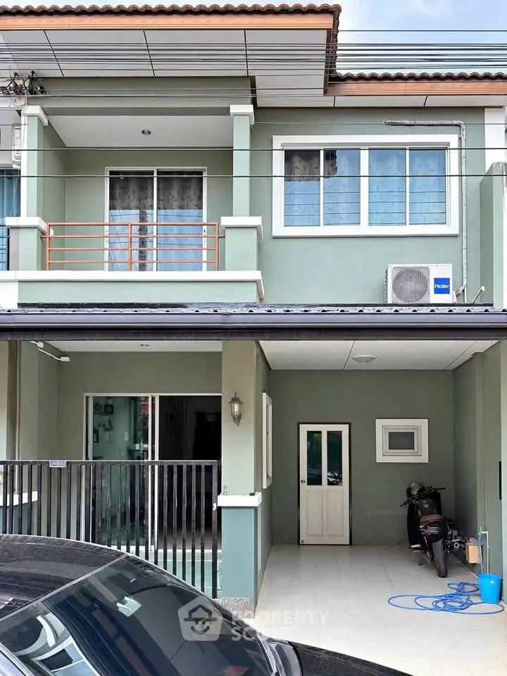 Charming two-story townhouse with balcony and covered parking in a serene neighborhood.
