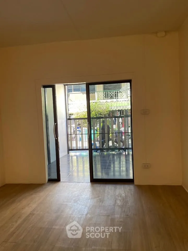Spacious room with sliding glass doors leading to a balcony, offering natural light and outdoor access.