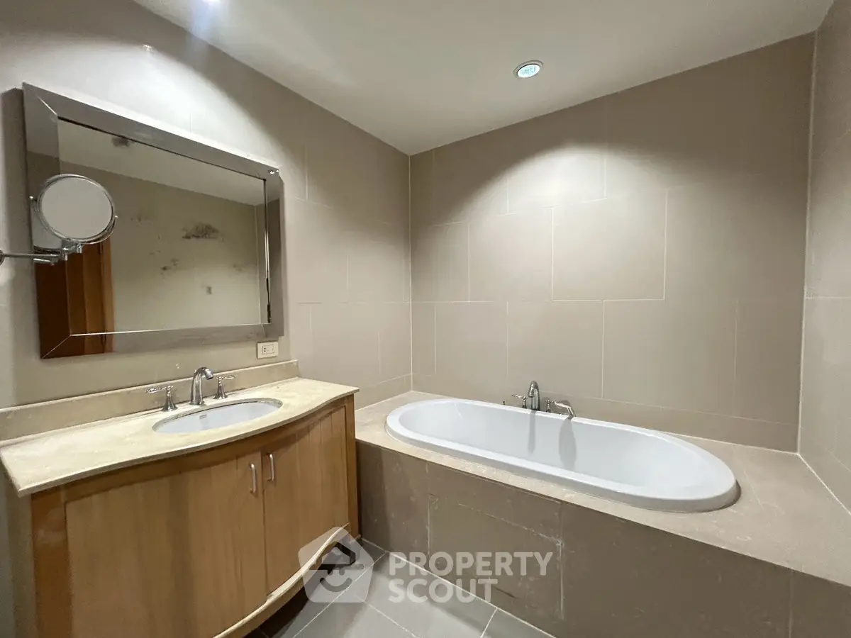 Modern bathroom with elegant bathtub and stylish vanity in a contemporary home.