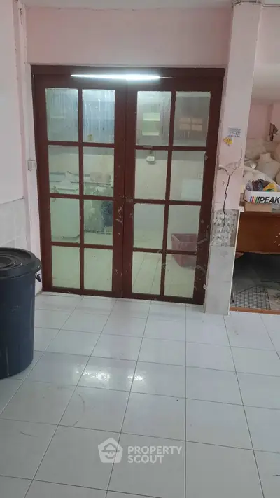 Spacious tiled interior with glass doors and ample storage potential.