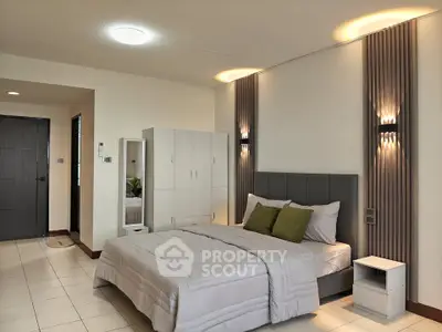 Spacious modern bedroom with stylish lighting and cozy decor