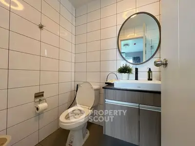 Modern bathroom with sleek fixtures and round mirror, perfect for contemporary living.