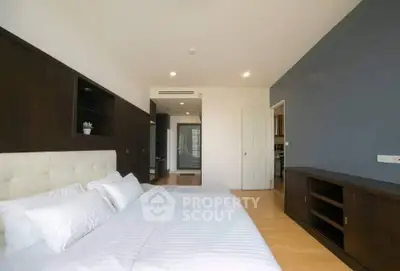 Spacious modern bedroom with elegant dark wood accents and ample natural light.