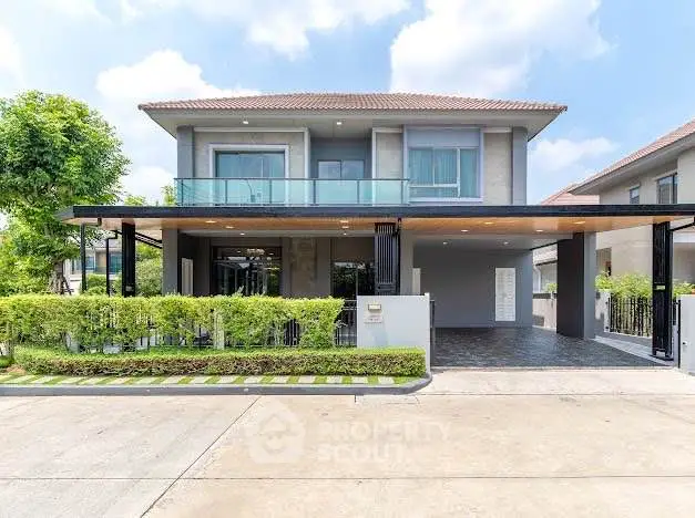 Modern two-story house with spacious driveway and lush greenery, perfect for family living.