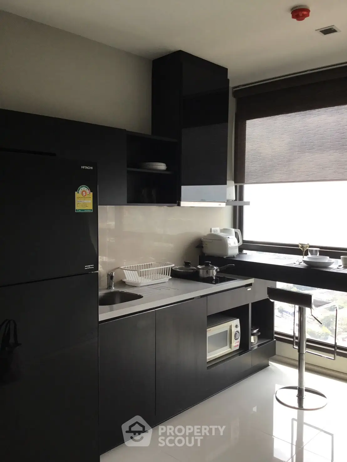 Modern kitchen with sleek black cabinets and large window view