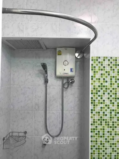 Modern bathroom with shower and water heater, featuring stylish green mosaic tiles.