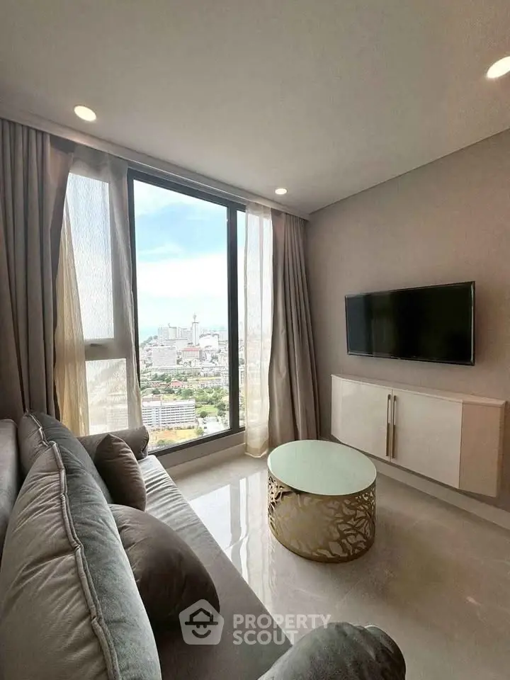 Modern living room with stunning city view, featuring sleek furniture and large windows.