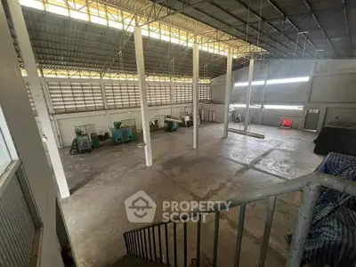 Spacious industrial warehouse with high ceilings and ample natural light, ideal for manufacturing or storage.