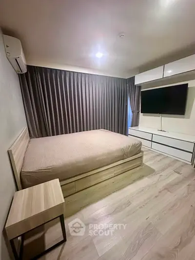 Modern bedroom with sleek design, featuring a large bed, built-in storage, and wall-mounted TV.
