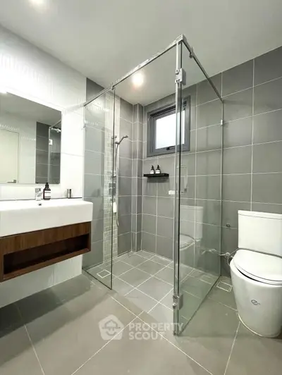 Modern bathroom with glass shower and sleek fixtures in contemporary home.