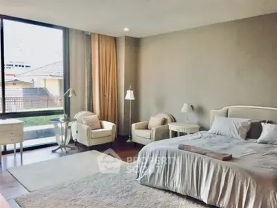 Spacious bedroom with elegant decor and large window view