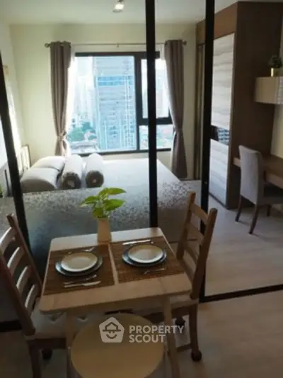 Modern studio apartment with city view, featuring cozy dining area and stylish bedroom.