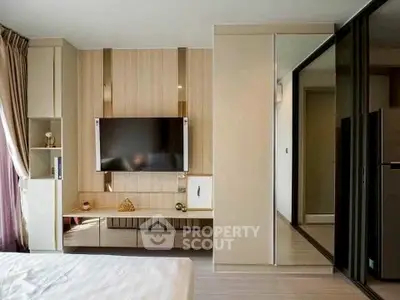 Modern bedroom with sleek TV setup and mirrored wardrobe