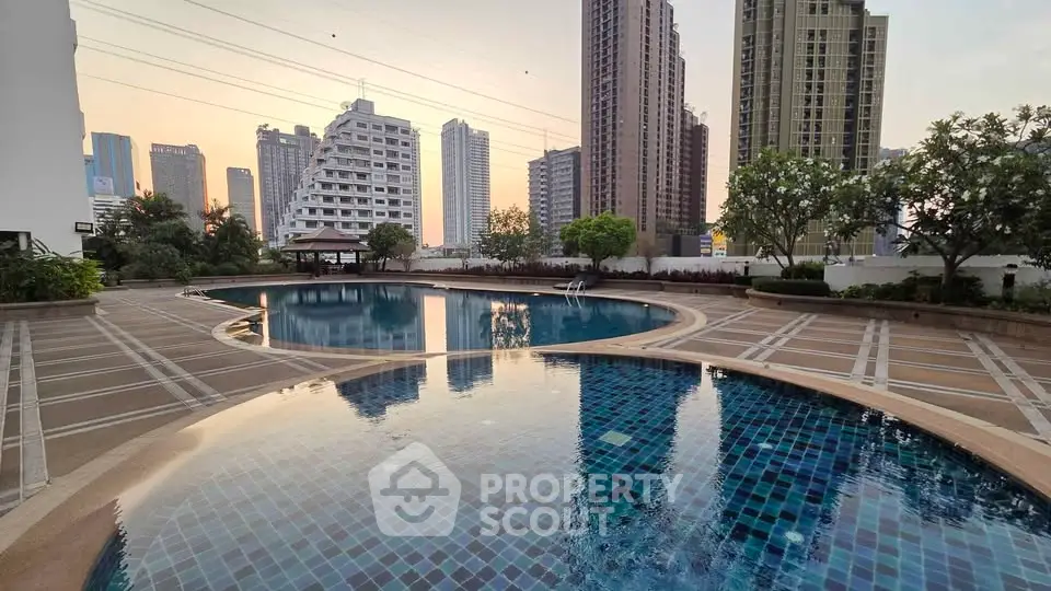 Luxurious urban pool area with stunning cityscape views at sunset, perfect for relaxation and leisure.