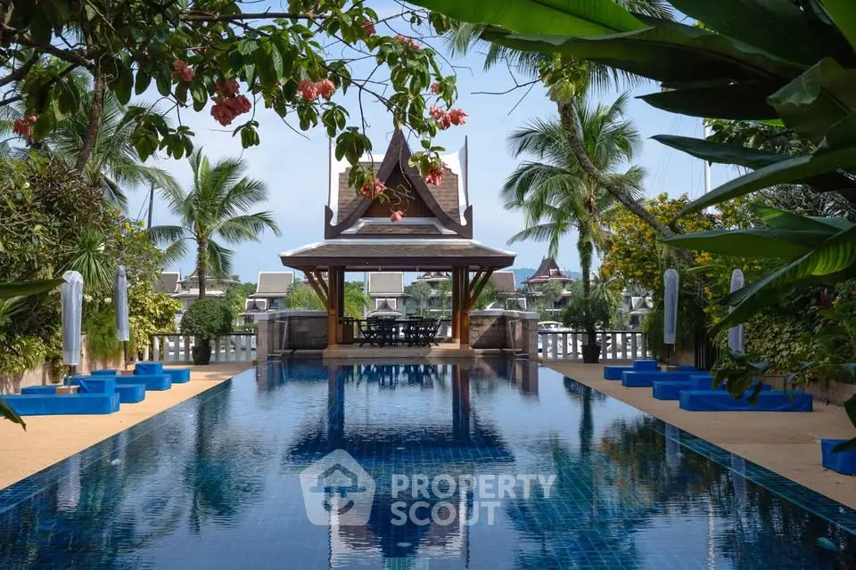 Luxurious tropical poolside with stunning architecture and lush greenery, perfect for relaxation and leisure.