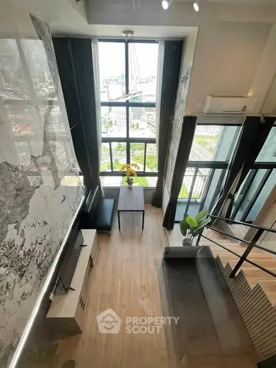 Stunning loft apartment with floor-to-ceiling windows and city view, featuring modern decor and open layout.