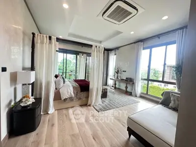 Luxurious bedroom with elegant decor and large windows offering natural light