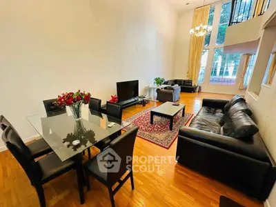 Spacious living room with high ceilings, elegant decor, and large windows for natural light.