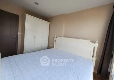 Cozy bedroom with white wardrobe and bed, perfect for relaxation.