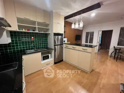 Modern kitchen with open layout and stainless steel appliances in stylish apartment.