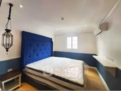 Cozy bedroom with blue accent wall and modern lighting