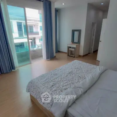 Spacious bedroom with modern decor, large window, and balcony access in a contemporary apartment.