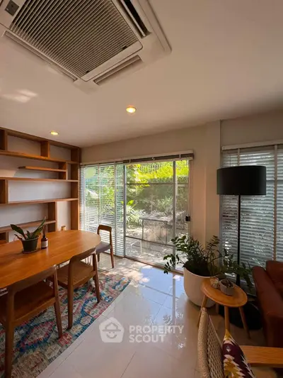 Charming living room with garden view, featuring modern furniture and abundant natural light.