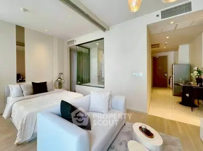 Modern studio apartment with elegant decor and open layout, featuring a cozy bed and stylish seating area.