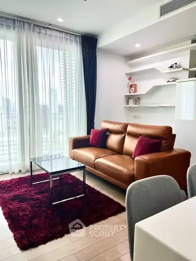 Modern living room with leather sofa, glass coffee table, and city view through large windows.