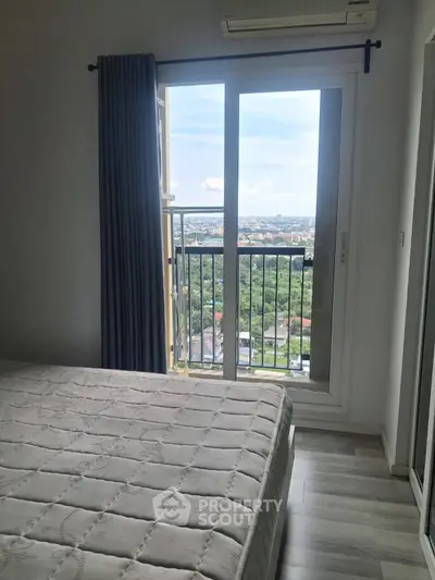 Bright bedroom with balcony offering stunning city view, featuring modern decor and ample natural light.