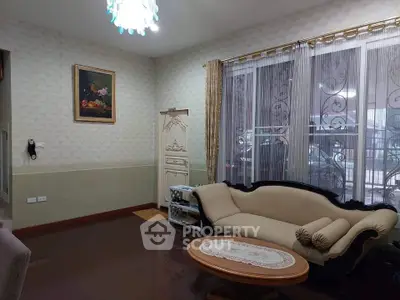 Elegant living room with classic sofa and large window, perfect for cozy gatherings.