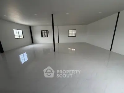 Spacious open-plan interior with tiled flooring and large windows, ideal for versatile living or office space.