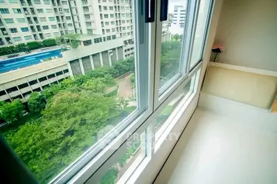 Bright apartment balcony with stunning view of lush greenery and modern buildings.