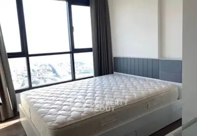 Spacious bedroom with large window offering stunning city views and ample natural light.