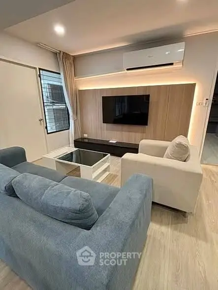 Modern living room with stylish furniture and wall-mounted TV