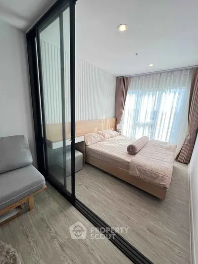 Modern bedroom with large windows and stylish decor in a contemporary apartment.