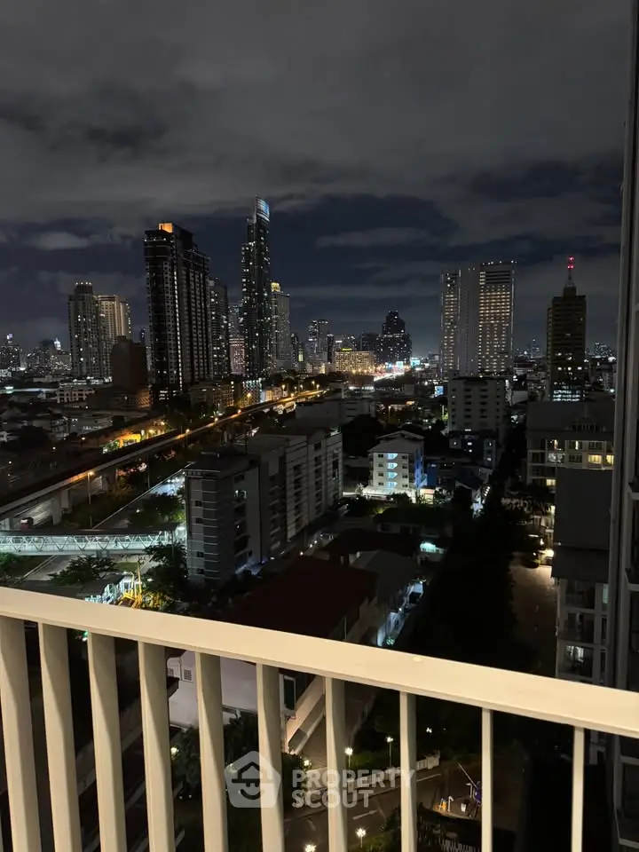Stunning city skyline view from a high-rise balcony at night, showcasing urban living.