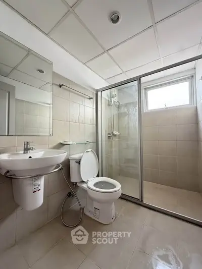 Modern bathroom with glass shower and sleek fixtures in a contemporary apartment.