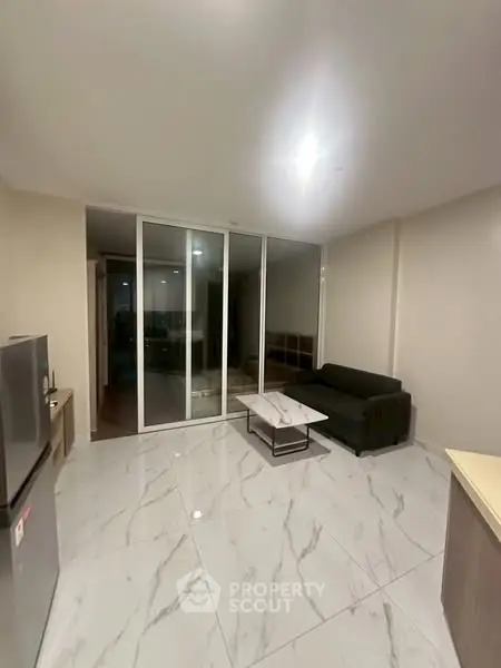 Modern living room with sleek marble flooring and glass sliding doors