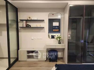 Modern bedroom with stylish vanity and glass wardrobe doors, perfect for urban living.