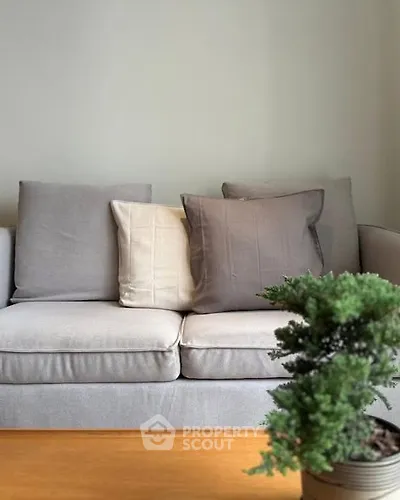 Stylish living room with modern gray sofa and decorative cushions.