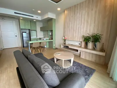 Modern open-plan living room with stylish kitchen and cozy seating area, perfect for contemporary living.