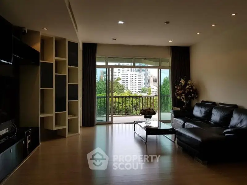 Spacious living room with modern decor and large balcony overlooking cityscape.