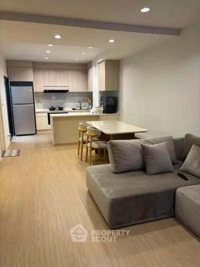 Modern open-plan kitchen and living room with sleek design and cozy seating area.