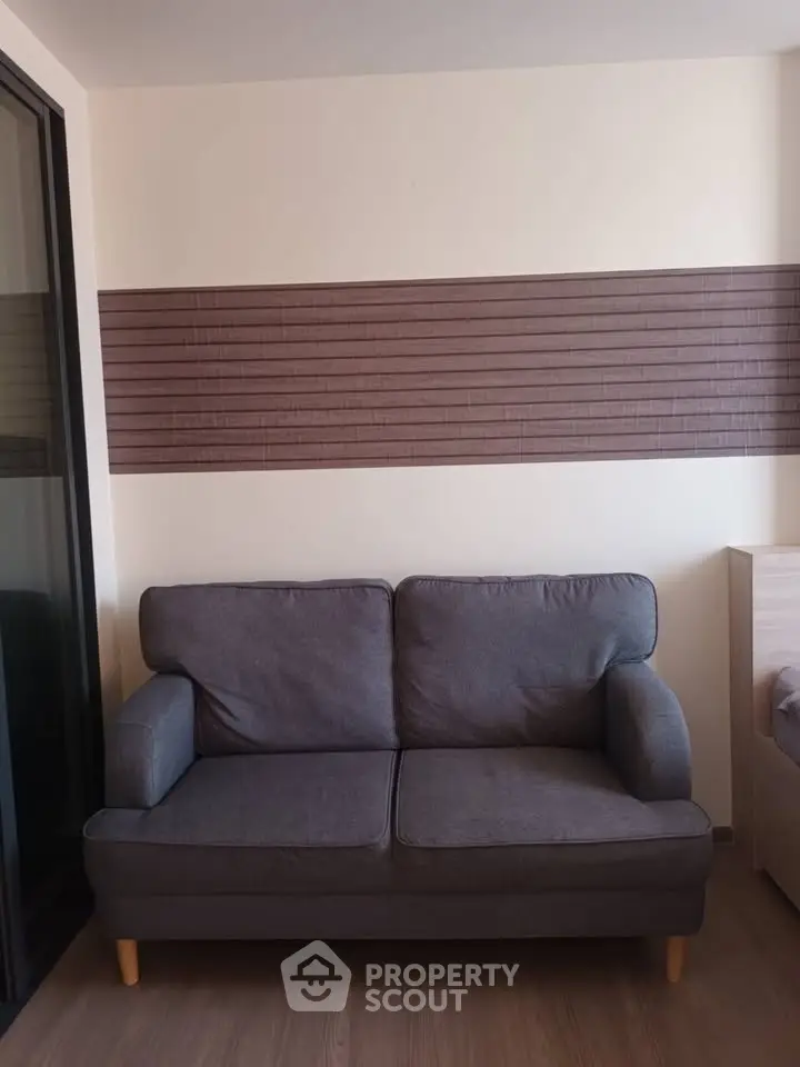 Cozy living room with modern gray sofa and stylish wall paneling