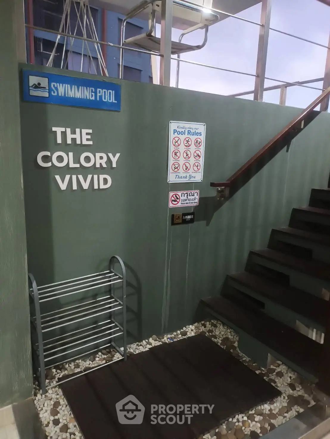 Stylish poolside entrance with modern staircase and pool rules signage.