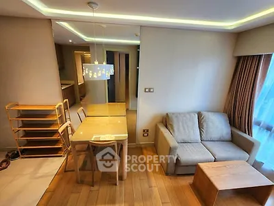 Modern living room with cozy sofa, dining table, and stylish lighting in a contemporary apartment.