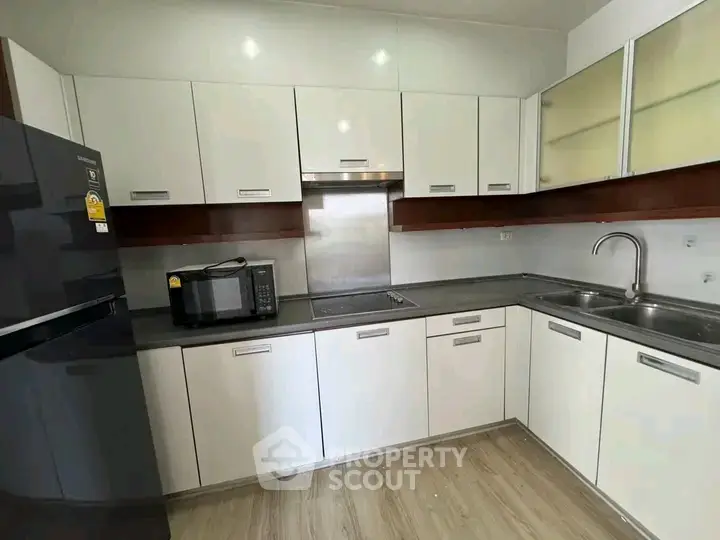 Modern kitchen with sleek cabinetry and stainless steel appliances in a contemporary apartment.