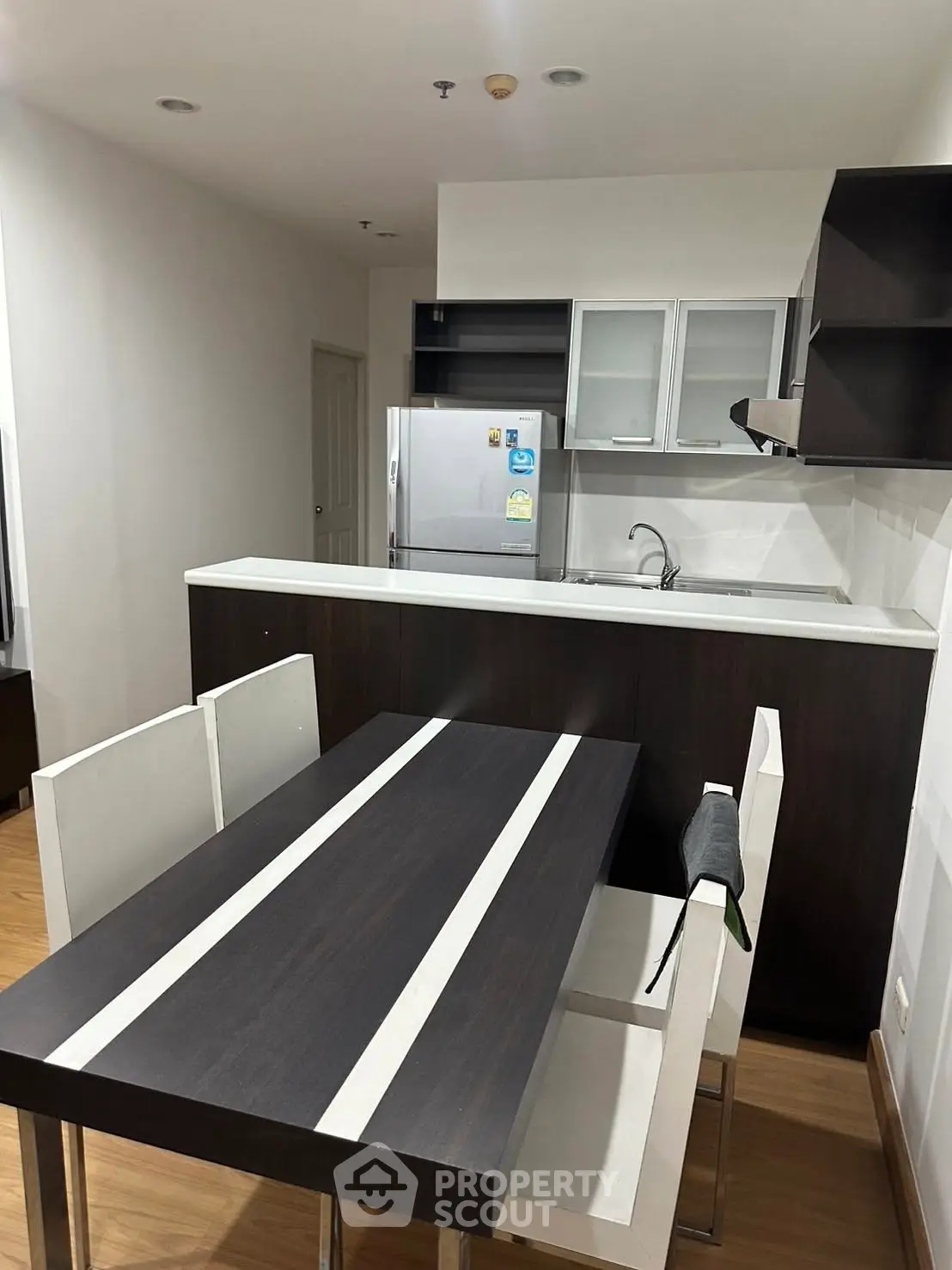 Modern kitchen with sleek dining area and stainless steel appliances.